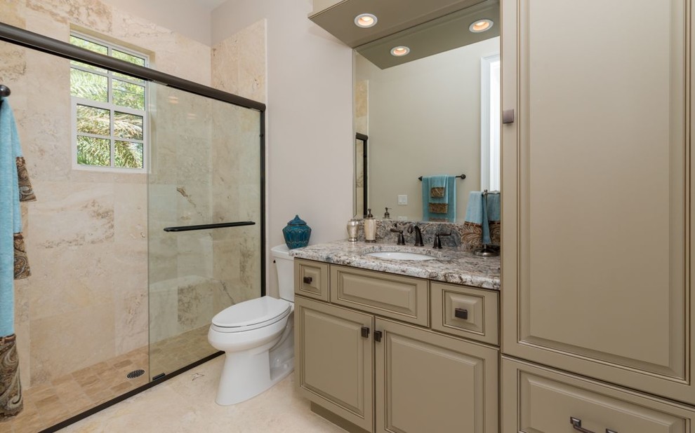 Alcove shower - mid-sized traditional master beige tile and stone tile travertine floor alcove shower idea in Tampa with recessed-panel cabinets, beige cabinets, a two-piece toilet, beige walls, an undermount sink and granite countertops