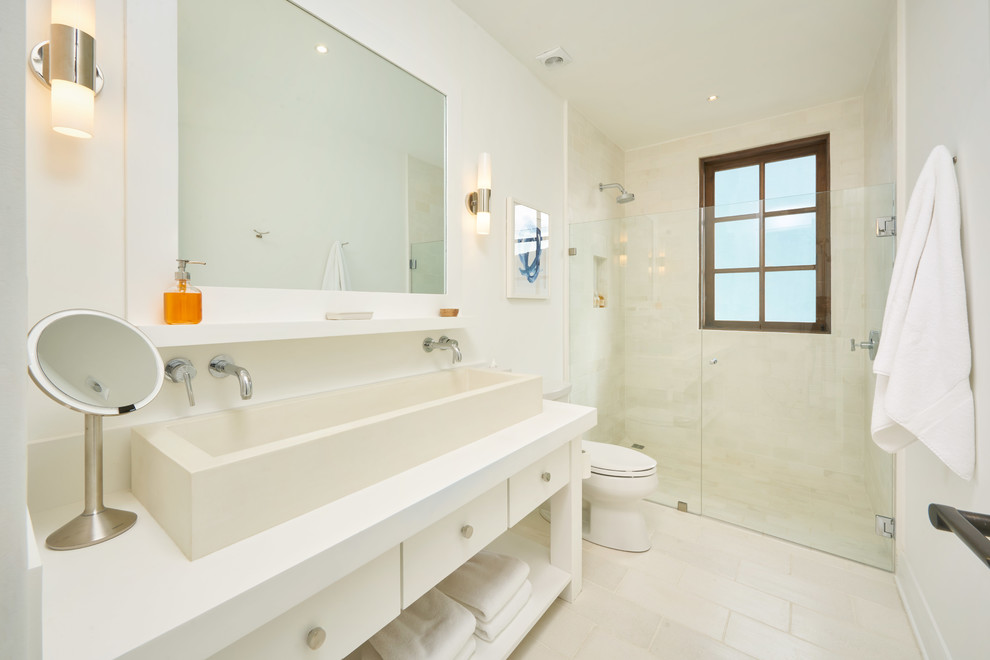 Medium sized beach style shower room bathroom in Other with freestanding cabinets, white cabinets, a built-in shower, a one-piece toilet, white tiles, cement tiles, white walls, cement flooring, a trough sink, concrete worktops, white floors, a hinged door and white worktops.