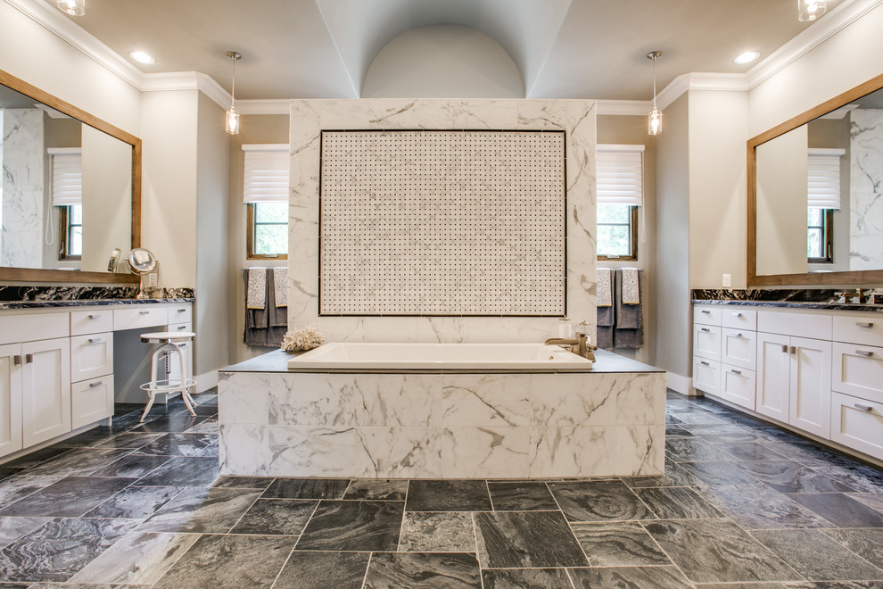 Immagine di una stanza da bagno chic con ante in stile shaker, ante bianche, vasca da incasso, piastrelle bianche e pareti beige