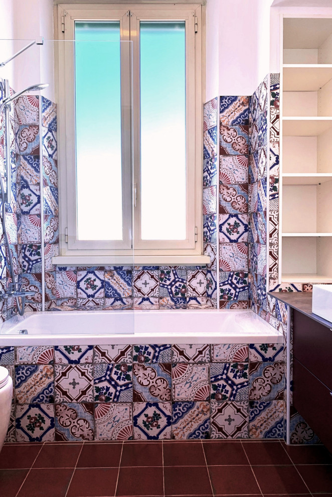 おしゃれなマスターバスルーム (ビデ、マルチカラーのタイル、セメントタイル、マルチカラーの壁、セラミックタイルの床、ベッセル式洗面器、洗面台1つ、紫のキャビネット、アルコーブ型浴槽、赤い床) の写真