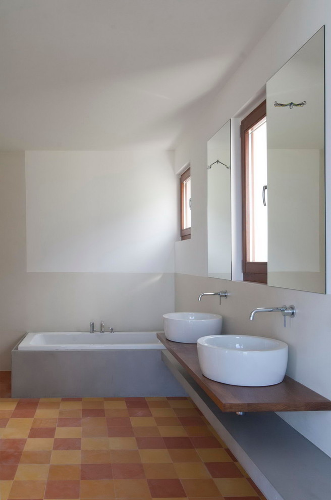 Photo of a medium sized contemporary ensuite bathroom in Other with a vessel sink, open cabinets, medium wood cabinets, wooden worktops, an alcove bath, a walk-in shower, green tiles, cement tiles and white walls.