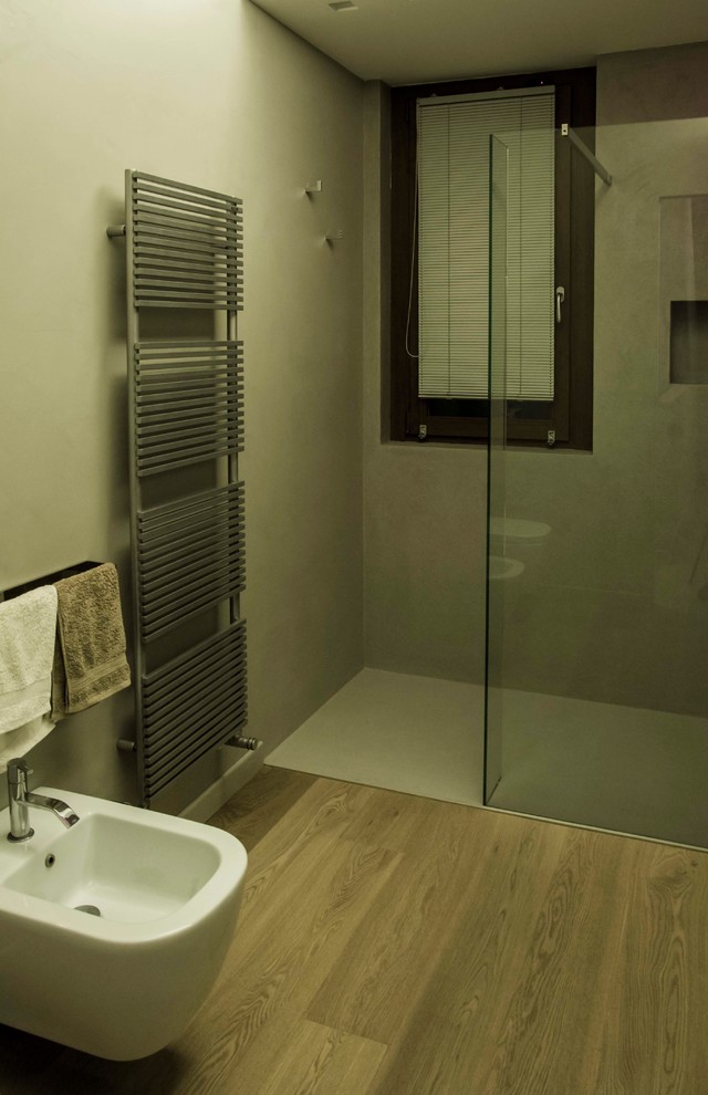 Foto di una stanza da bagno con doccia moderna di medie dimensioni con doccia a filo pavimento, WC a due pezzi, pareti grigie, parquet chiaro, pavimento marrone, doccia aperta e lavabo integrato