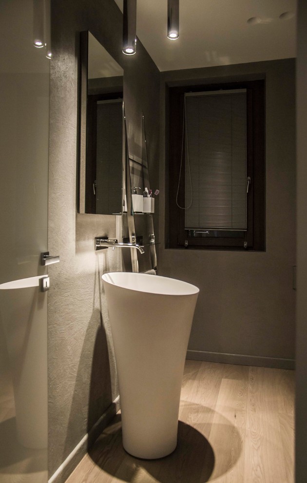 Idee per una stanza da bagno padronale moderna di medie dimensioni con ante grigie, WC a due pezzi, piastrelle grigie, pareti grigie, parquet chiaro, lavabo a colonna e pavimento marrone