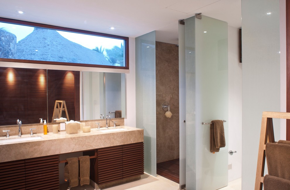 Imagen de cuarto de baño exótico con lavabo bajoencimera, ducha empotrada y paredes blancas