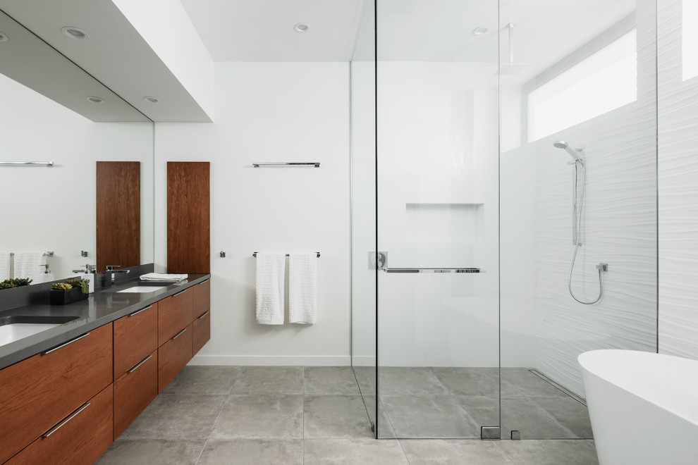 Example of a trendy master white tile and ceramic tile porcelain tile and gray floor bathroom design in Phoenix with flat-panel cabinets, white walls, an undermount sink, quartz countertops, a hinged shower door, gray countertops and medium tone wood cabinets