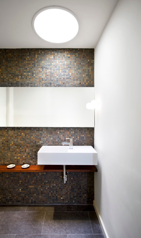 Imagen de cuarto de baño actual con paredes multicolor y suelo de madera en tonos medios