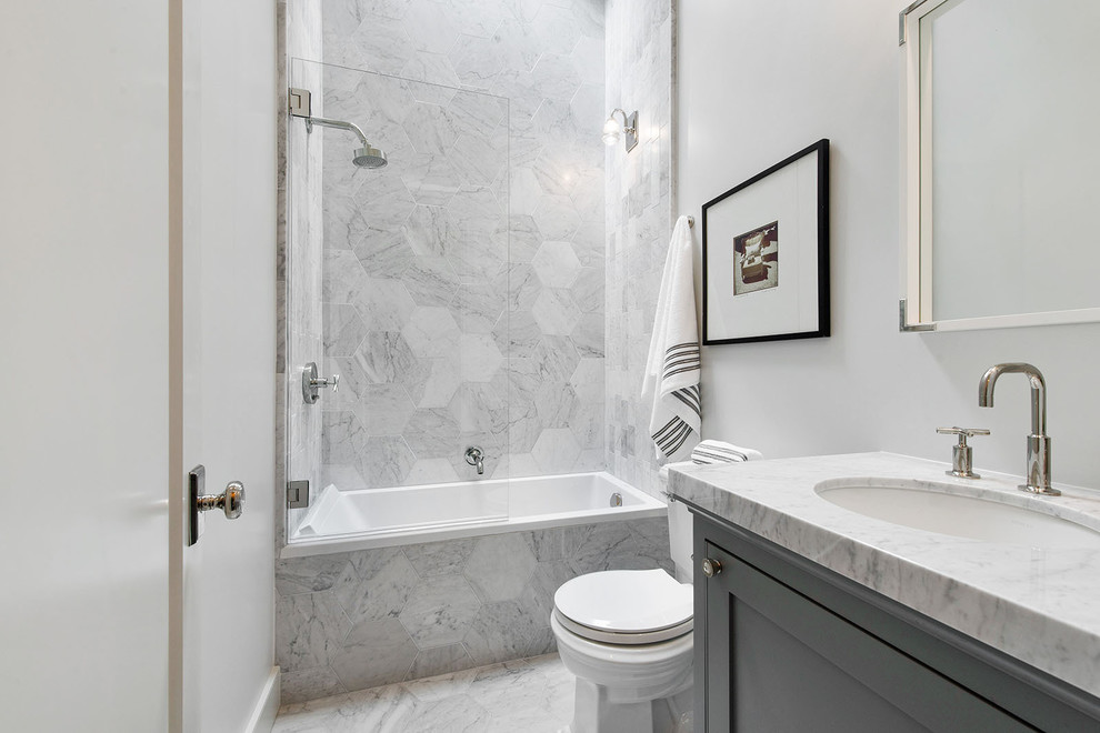 Photo of a medium sized contemporary bathroom in San Francisco with shaker cabinets, grey cabinets, an alcove bath, a shower/bath combination, a one-piece toilet, grey tiles, marble tiles, grey walls, marble flooring, a submerged sink, marble worktops, grey floors and a hinged door.