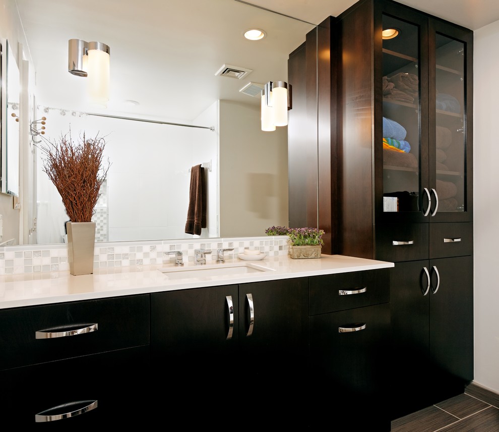 This is an example of a contemporary bathroom in DC Metro with mosaic tiles, a submerged sink and dark wood cabinets.