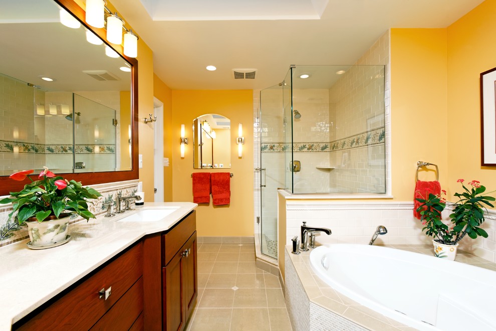 Modelo de cuarto de baño actual con baldosas y/o azulejos en mosaico, lavabo bajoencimera, paredes amarillas y bañera encastrada