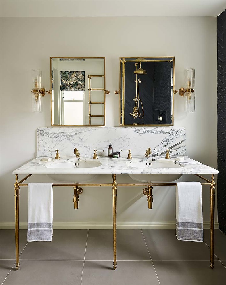 Klassisk inredning av ett badrum med dusch, med grå kakel, vita väggar, ett undermonterad handfat och marmorbänkskiva