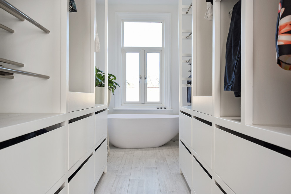 Foto på ett stort funkis badrum, med ett fristående badkar, våtrum, en vägghängd toalettstol, grå kakel, grå väggar, ett väggmonterat handfat, beiget golv och dusch med gångjärnsdörr