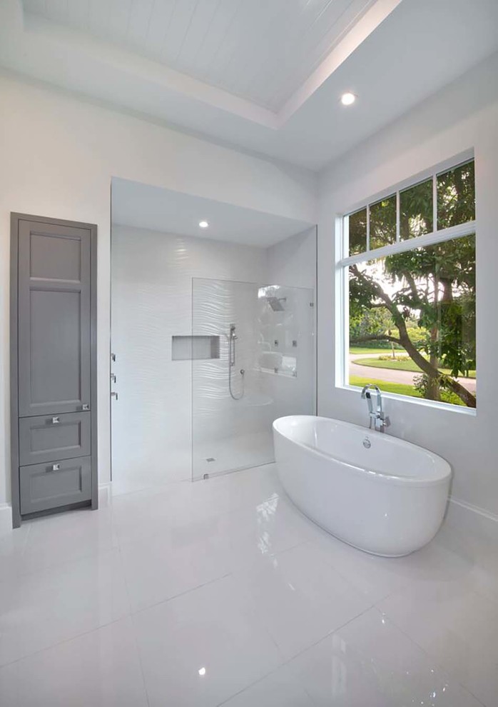 Immagine di una stanza da bagno padronale mediterranea di medie dimensioni con ante con riquadro incassato, ante bianche, vasca ad alcova, piastrelle grigie e pareti grigie