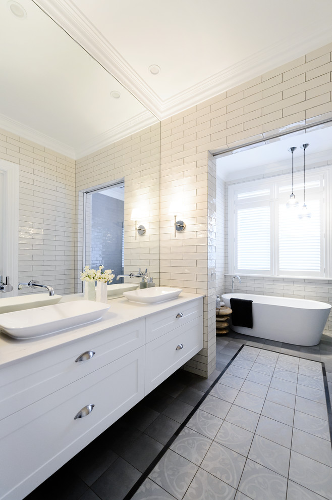 Пример оригинального дизайна: большая главная ванная комната в современном стиле с фасадами в стиле шейкер, белыми фасадами, отдельно стоящей ванной, душем в нише, унитазом-моноблоком, белой плиткой, керамической плиткой, белыми стенами, полом из керамической плитки, раковиной с пьедесталом, столешницей из гранита, серым полом, шторкой для ванной и белой столешницей