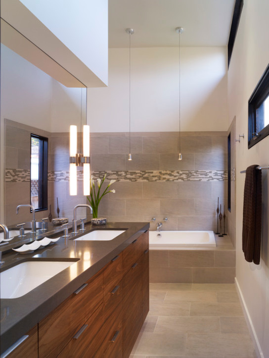 Medium sized modern ensuite bathroom in Los Angeles with a submerged sink, freestanding cabinets, dark wood cabinets, engineered stone worktops, a built-in bath, a shower/bath combination, a wall mounted toilet, beige tiles, ceramic tiles, beige walls and ceramic flooring.