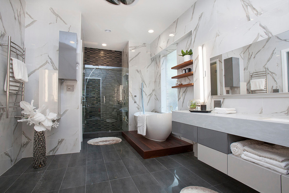 Foto på ett stort funkis grå en-suite badrum, med släta luckor, vita skåp, ett fristående badkar, en dusch i en alkov, vit kakel, marmorkakel, vita väggar, skiffergolv, ett undermonterad handfat, marmorbänkskiva, grått golv och dusch med gångjärnsdörr