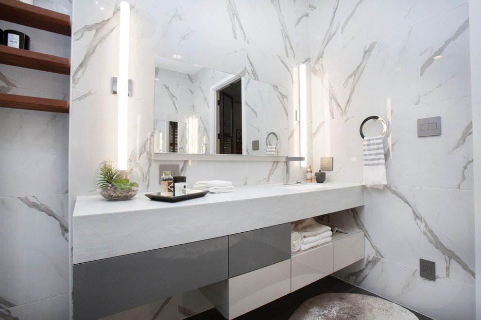 Свежая идея для дизайна: большая главная ванная комната в современном стиле с плоскими фасадами, белыми фасадами, гидромассажной ванной, унитазом-моноблоком, серой плиткой, керамогранитной плиткой, накладной раковиной, столешницей из известняка, белыми стенами и полом из керамической плитки - отличное фото интерьера