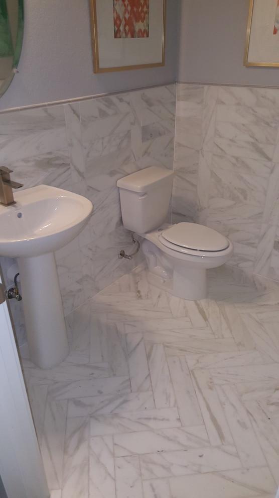Inredning av ett modernt badrum, med vit kakel och marmorbänkskiva