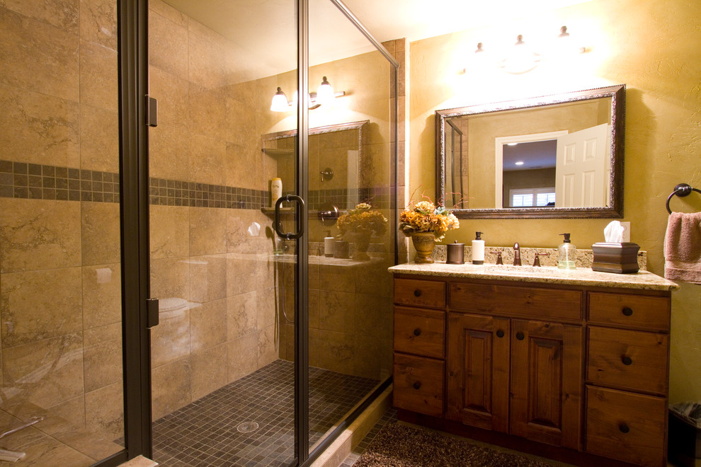 Inredning av ett rustikt stort badrum med dusch, med luckor med upphöjd panel, skåp i mörkt trä, en dusch i en alkov, en toalettstol med separat cisternkåpa, brun kakel, porslinskakel, klinkergolv i porslin, ett undermonterad handfat, granitbänkskiva och gula väggar