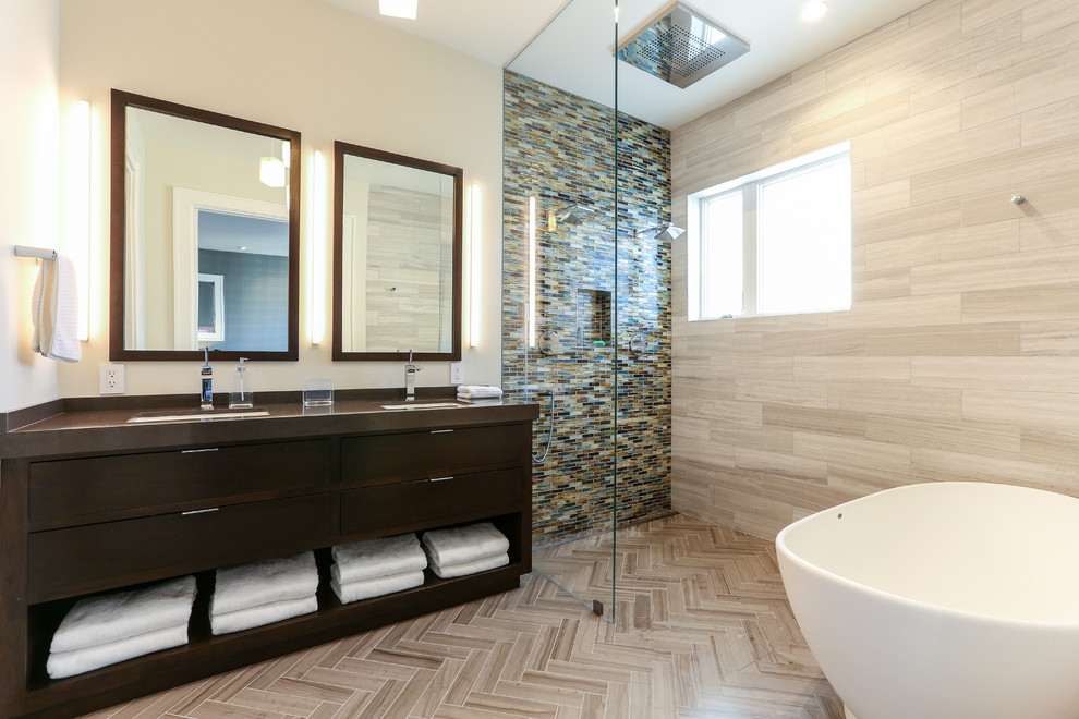 Cette image montre une salle de bain design en bois foncé avec un placard à porte plane, une baignoire indépendante, une douche ouverte, un carrelage marron, un carrelage gris et un mur jaune.