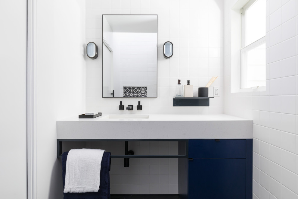 Exempel på ett litet modernt vit vitt badrum med dusch, med släta luckor, blå skåp, vit kakel, porslinskakel, vita väggar, klinkergolv i porslin och ett undermonterad handfat