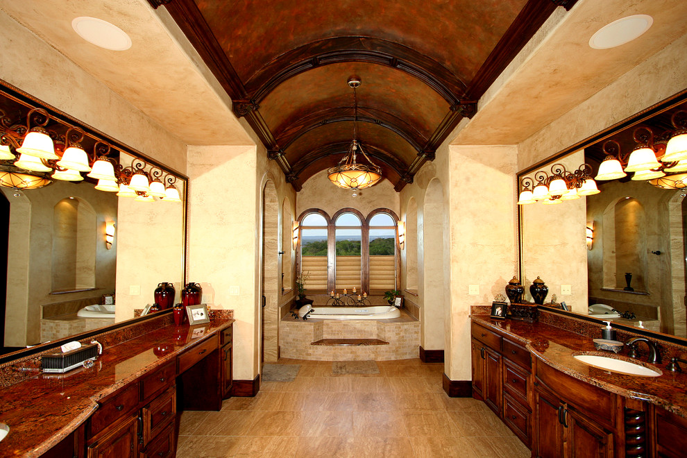 Foto de cuarto de baño principal mediterráneo con lavabo bajoencimera, puertas de armario de madera en tonos medios, encimera de granito, bañera encastrada y suelo de travertino
