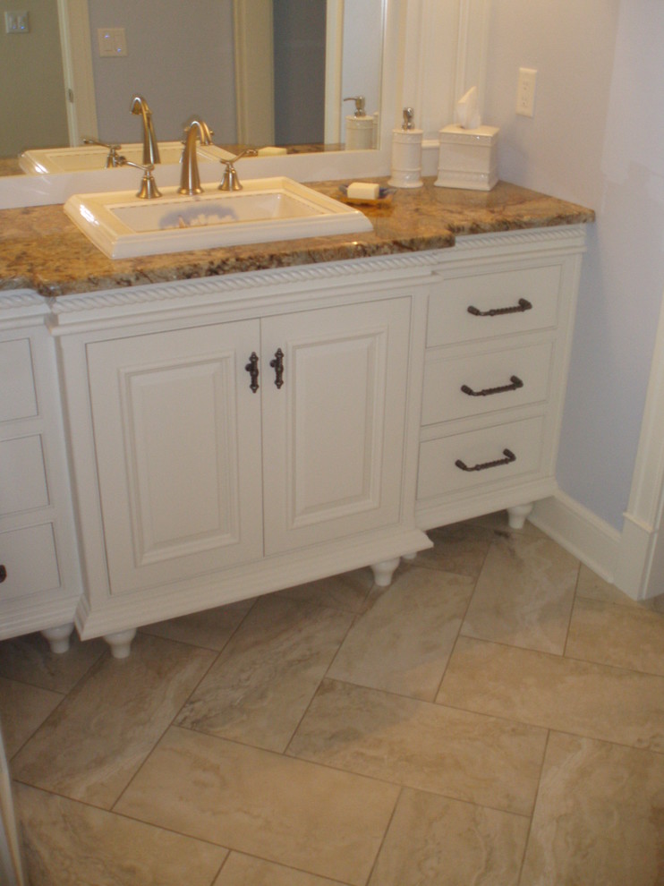 Klassisk inredning av ett stort badrum, med vita skåp, ett hörnbadkar, beige kakel, tunnelbanekakel, vita väggar, marmorgolv och beiget golv