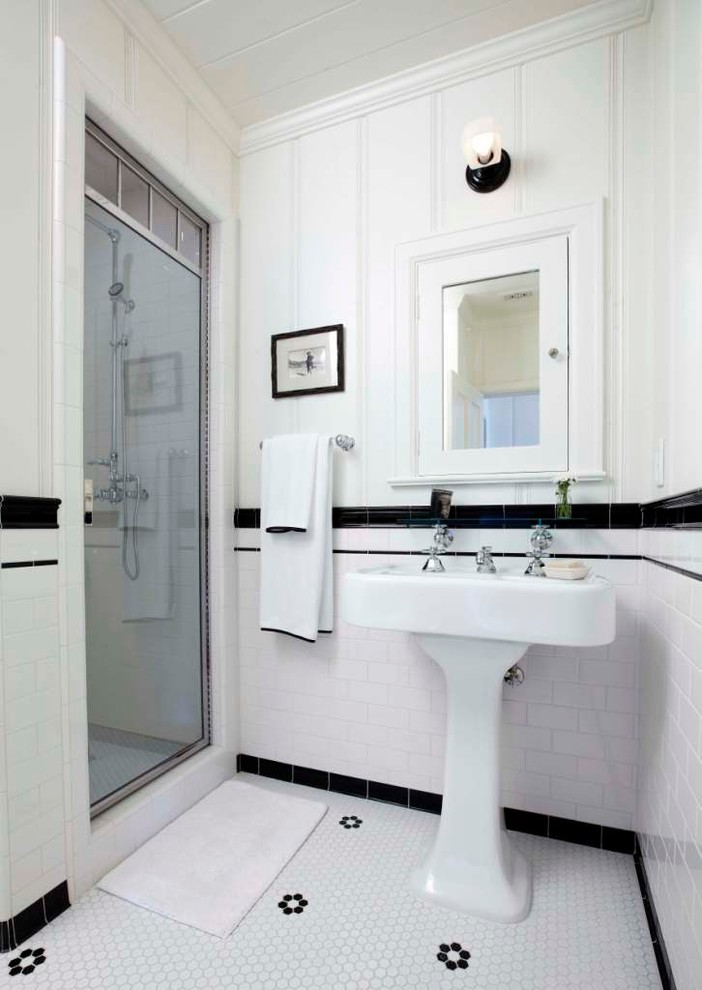 Modelo de cuarto de baño clásico de tamaño medio con lavabo con pedestal, ducha empotrada, baldosas y/o azulejos blancos, baldosas y/o azulejos de cemento, paredes blancas, suelo con mosaicos de baldosas y aseo y ducha