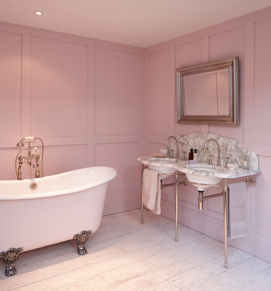 На фото: ванная комната в стиле кантри с отдельно стоящей ванной, удлиненной плиткой и розовыми стенами