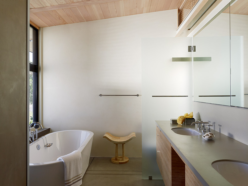 На фото: ванная комната в современном стиле с отдельно стоящей ванной и окном