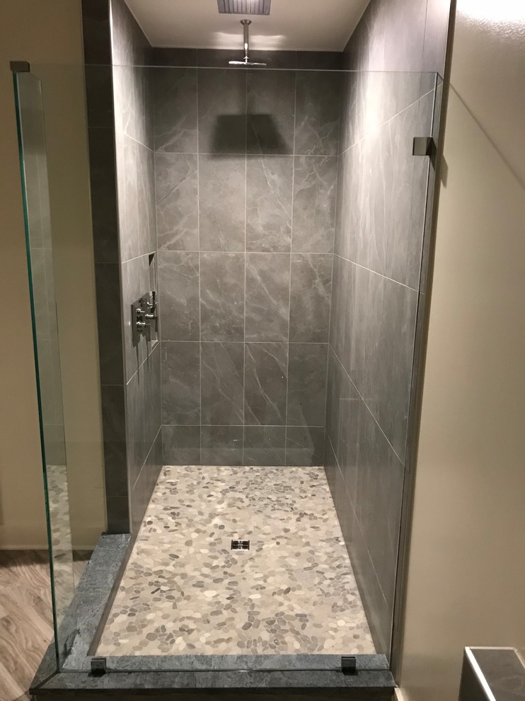 Modelo de cuarto de baño principal clásico renovado de tamaño medio con puertas de armario blancas, bañera exenta, ducha esquinera, paredes blancas, suelo vinílico, suelo marrón y encimeras negras