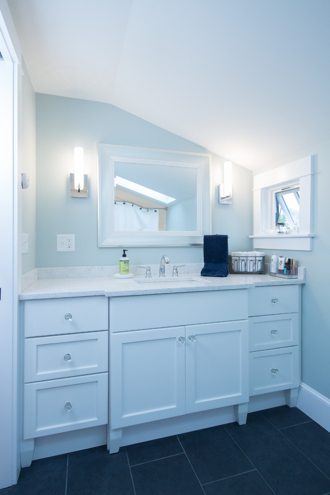 This is an example of a coastal bathroom in Boston with shaker cabinets, white cabinets, a freestanding bath, a shower/bath combination, a two-piece toilet, white tiles, metro tiles, green walls, ceramic flooring, a submerged sink, engineered stone worktops, black floors, a shower curtain and white worktops.