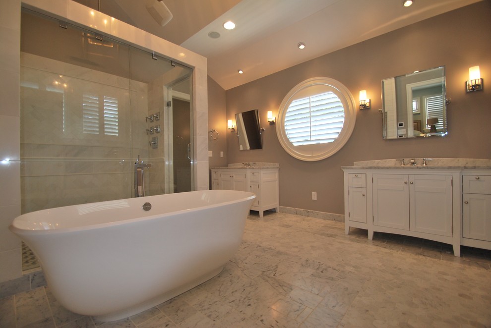 Пример оригинального дизайна: большая главная ванная комната в стиле неоклассика (современная классика) с фасадами с декоративным кантом, белыми фасадами, отдельно стоящей ванной, угловым душем, раздельным унитазом, серой плиткой, мраморной плиткой, серыми стенами, мраморным полом, врезной раковиной, мраморной столешницей, серым полом и душем с распашными дверями