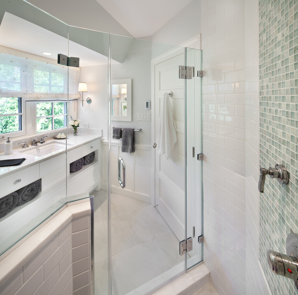 Diseño de cuarto de baño tradicional con armarios con paneles lisos, puertas de armario blancas, ducha esquinera, baldosas y/o azulejos blancos, baldosas y/o azulejos de cemento y encimeras blancas