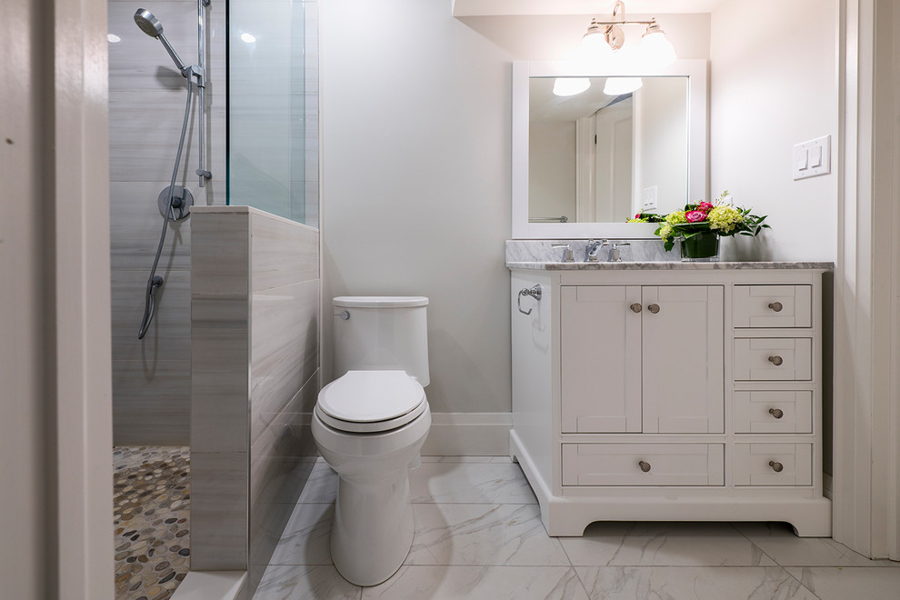 Cette photo montre une salle de bain moderne de taille moyenne avec un placard à porte shaker, des portes de placard blanches, WC à poser, un carrelage gris, un mur blanc, un lavabo encastré, un sol multicolore, aucune cabine et un plan de toilette multicolore.
