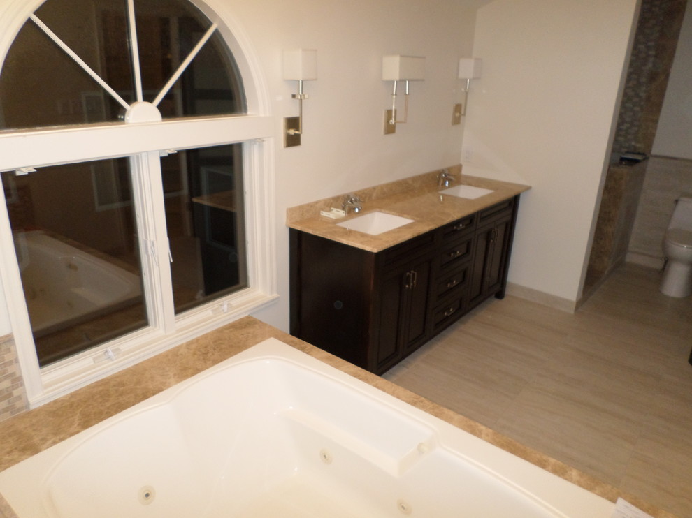 Réalisation d'une grande salle de bain principale minimaliste en bois foncé avec un lavabo encastré, un placard avec porte à panneau encastré, un plan de toilette en marbre, une baignoire posée, un carrelage beige, mosaïque, un mur blanc, un sol en carrelage de porcelaine et un sol beige.