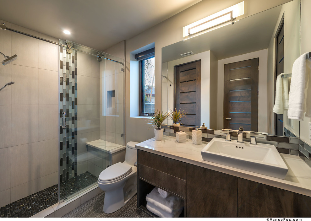 Medium sized contemporary family bathroom in Other with flat-panel cabinets, brown cabinets, a one-piece toilet, black tiles, glass tiles, beige walls, ceramic flooring, a vessel sink, quartz worktops, grey floors, a sliding door and beige worktops.