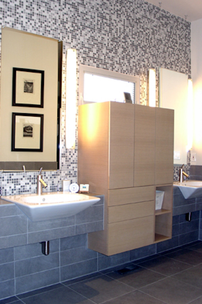 Inspiration pour une salle de bain principale design en bois clair de taille moyenne avec une vasque, un placard à porte plane, un plan de toilette en carrelage, un carrelage gris, des carreaux de porcelaine, un mur multicolore et un sol en carrelage de porcelaine.