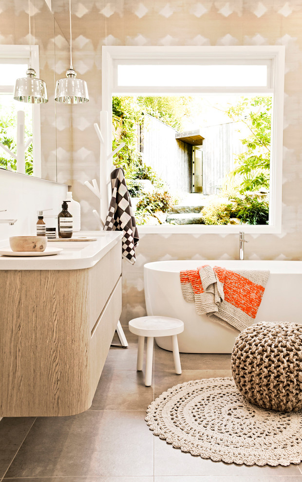 Источник вдохновения для домашнего уюта: ванная комната среднего размера в современном стиле с плоскими фасадами, светлыми деревянными фасадами и отдельно стоящей ванной