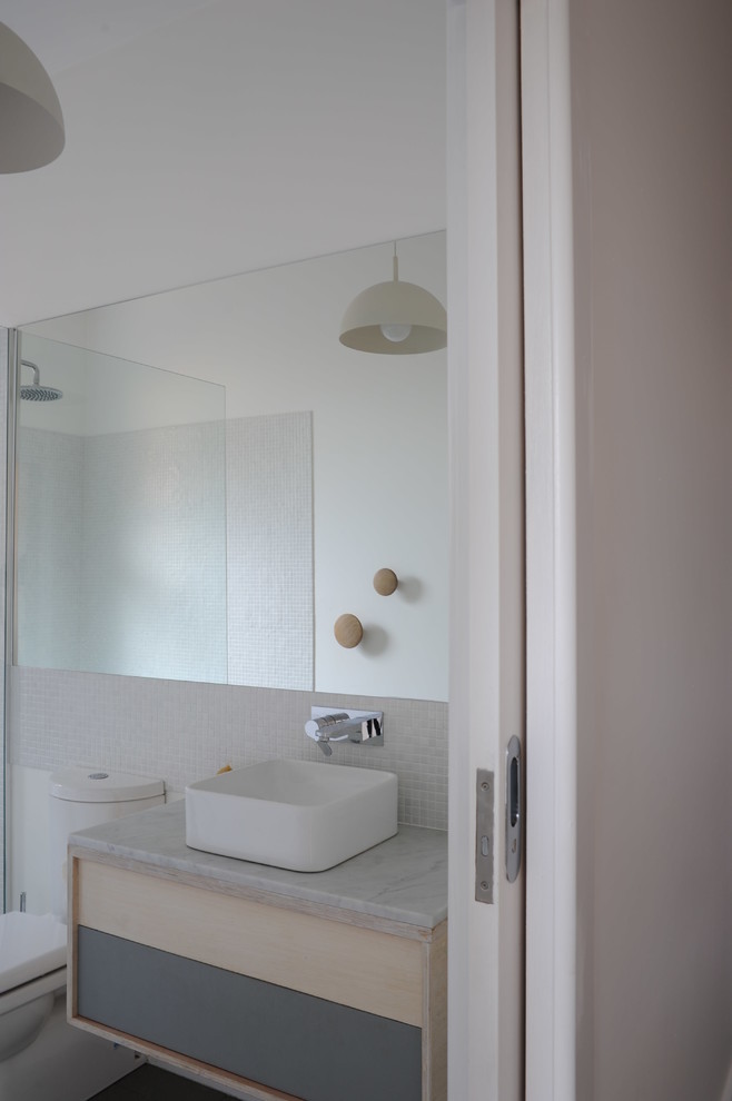 Пример оригинального дизайна: маленькая ванная комната в современном стиле с светлыми деревянными фасадами, мраморной столешницей, открытым душем, белой плиткой, плиткой мозаикой, белыми стенами и душевой кабиной для на участке и в саду