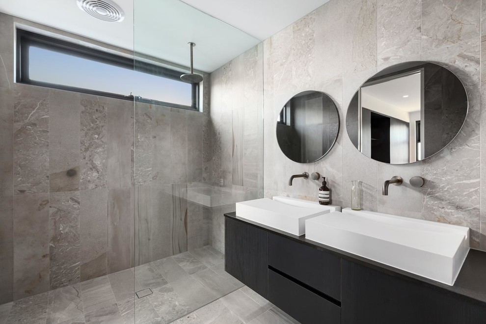 Exempel på ett stort modernt svart svart en-suite badrum, med släta luckor, svarta skåp, en dubbeldusch, en toalettstol med hel cisternkåpa, grå kakel, marmorkakel, grå väggar, marmorgolv, ett konsol handfat, marmorbänkskiva, grått golv och med dusch som är öppen