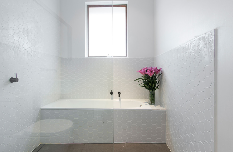 Cette image montre une salle de bain design de taille moyenne avec une baignoire en alcôve, une douche ouverte, un carrelage blanc, un mur blanc, un sol en carrelage de porcelaine et des carreaux de céramique.