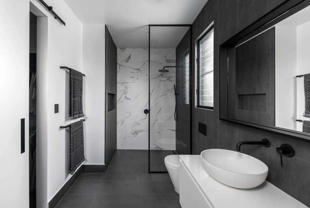 Inredning av ett modernt vit vitt en-suite badrum, med släta luckor, vita skåp, våtrum, grå kakel, vit kakel, vita väggar, ett fristående handfat, grått golv och med dusch som är öppen
