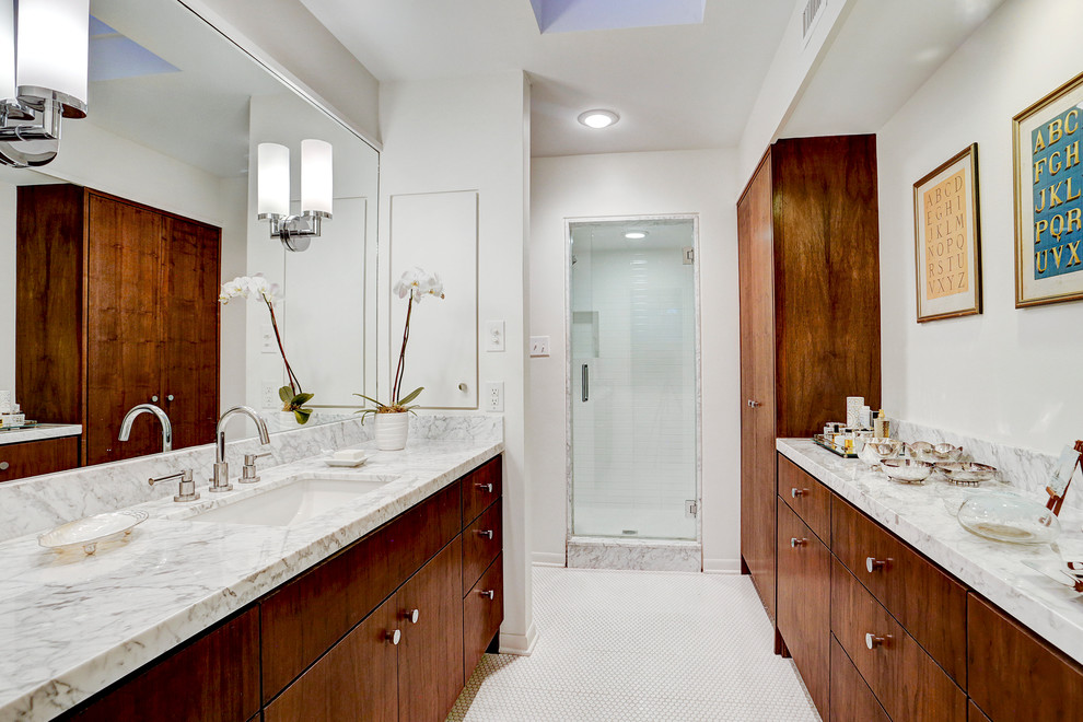 Свежая идея для дизайна: главная ванная комната среднего размера в стиле ретро с плоскими фасадами, темными деревянными фасадами, отдельно стоящей ванной, душем в нише, унитазом-моноблоком, белой плиткой, керамической плиткой, белыми стенами, полом из мозаичной плитки, врезной раковиной, мраморной столешницей, белым полом и душем с распашными дверями - отличное фото интерьера