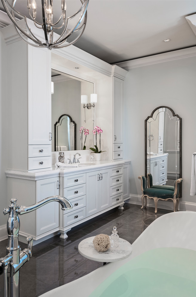 Idéer för ett stort klassiskt vit en-suite badrum, med luckor med infälld panel, vita skåp, ett fristående badkar, grå väggar, klinkergolv i porslin, marmorbänkskiva och grått golv