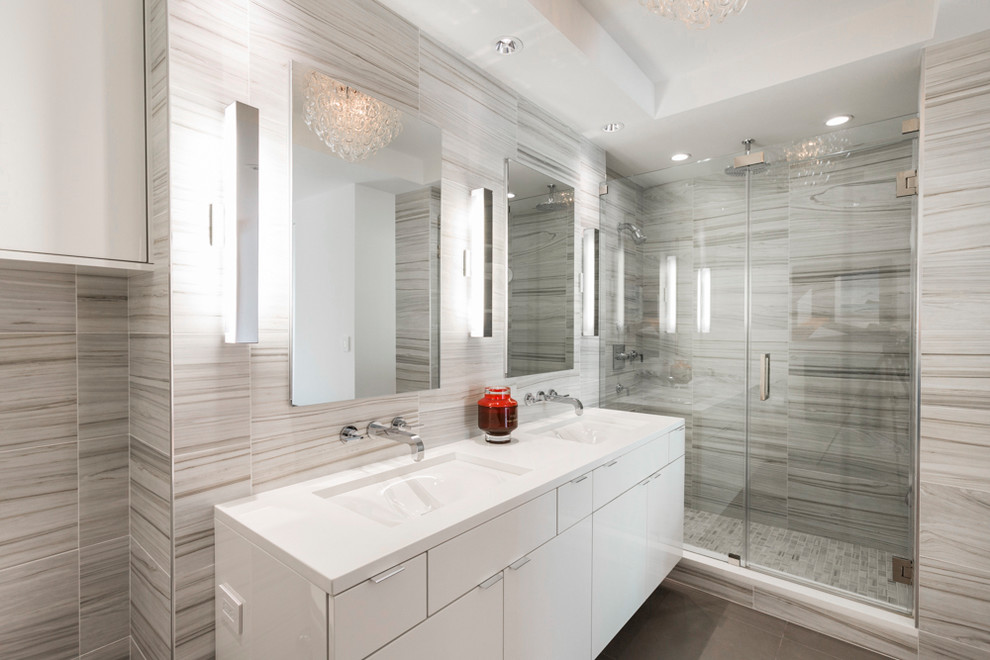 Immagine di una stanza da bagno contemporanea con ante lisce, ante bianche, doccia alcova, piastrelle grigie, lavabo sottopiano, pavimento grigio e porta doccia a battente