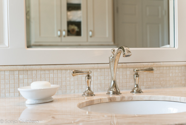 Large classic ensuite bathroom in Dallas with an integrated sink, recessed-panel cabinets, white cabinets, marble worktops, a built-in bath, a shower/bath combination, a one-piece toilet, beige tiles, stone slabs, beige walls and limestone flooring.