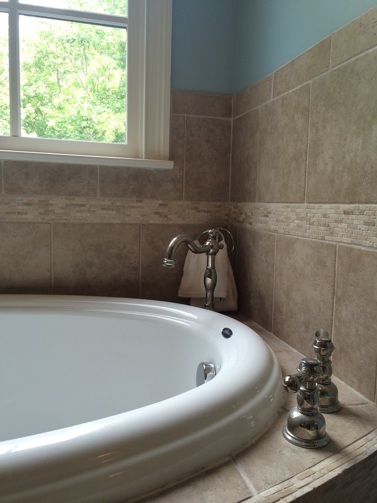 Example of a classic master ceramic tile drop-in bathtub design in Raleigh with blue walls