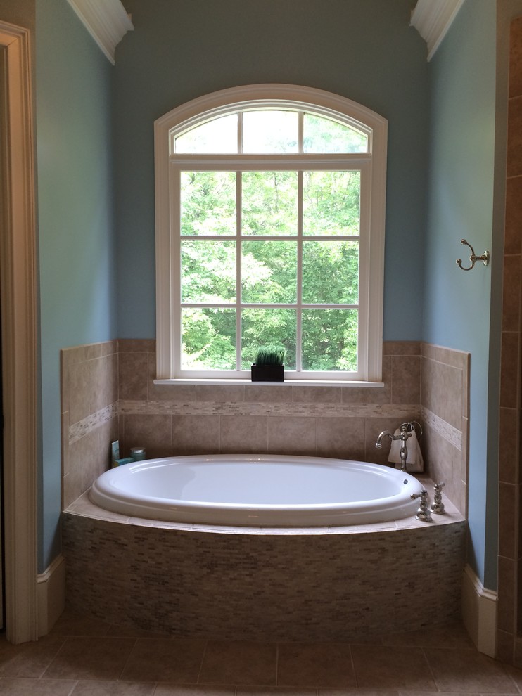 Cette photo montre une salle de bain principale chic avec une baignoire posée, un mur bleu et un sol en carrelage de céramique.