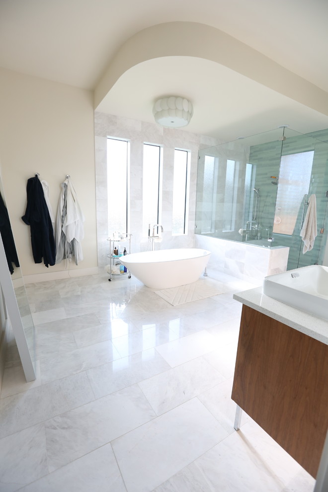 Inspiration for a mid-sized contemporary master gray tile and glass sheet marble floor and white floor bathroom remodel in Dallas with recessed-panel cabinets, medium tone wood cabinets, a two-piece toilet, white walls, a vessel sink, solid surface countertops and a hinged shower door