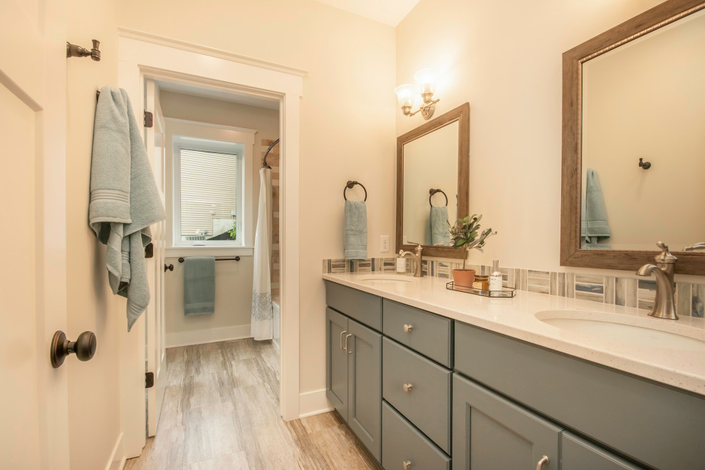 Exempel på ett klassiskt vit vitt badrum, med luckor med infälld panel, grå skåp, en dusch i en alkov, en toalettstol med separat cisternkåpa, flerfärgad kakel, glaskakel, vita väggar, vinylgolv, bänkskiva i kvarts, grått golv och dusch med duschdraperi